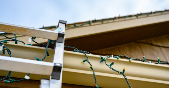 Ladder on house with christmas lights